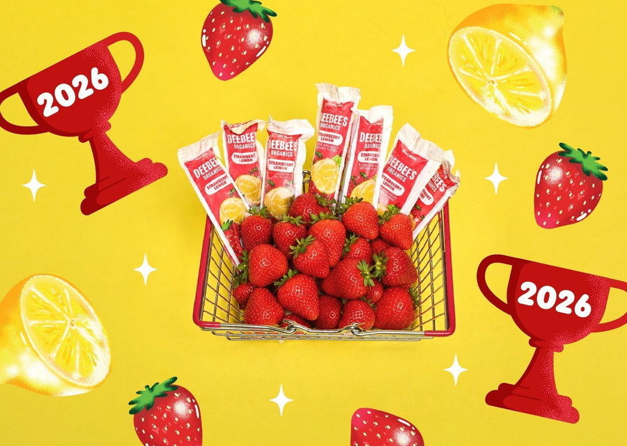 DeeBee’s Organics SuperFruit Strawberry Lemon Freezies with fresh strawberries in a mini cart on a bright yellow background